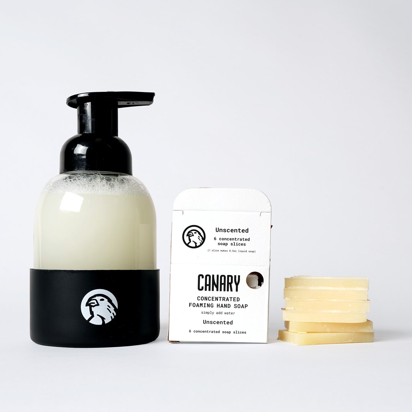 Image of Unscented Foaming Hand Soap. Sustainable refillable glass bottle filled with soap and 6 soap slices next to product.