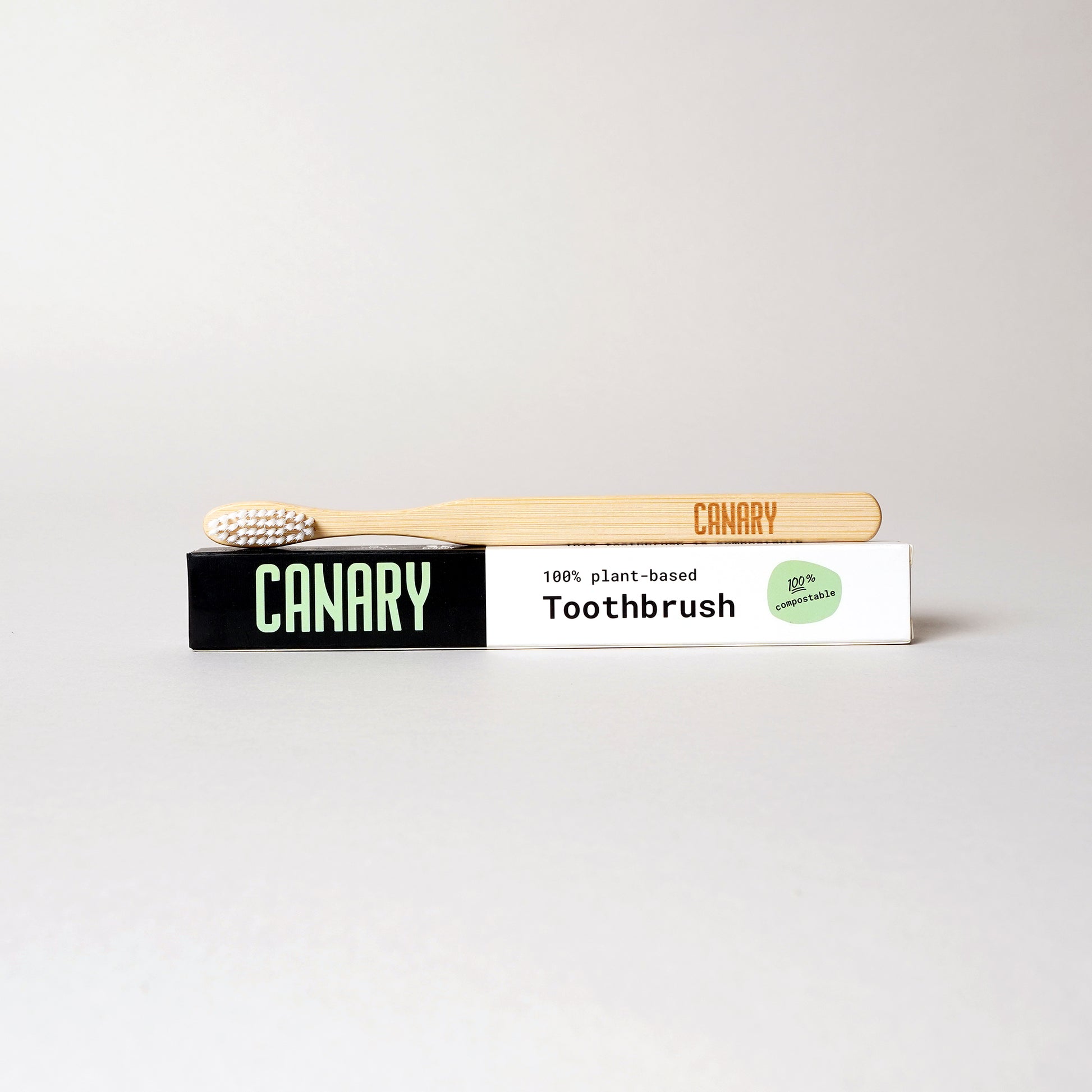 Canary plant-based and fully compostable bamboo toothbrush sitting on the box. Single unit.