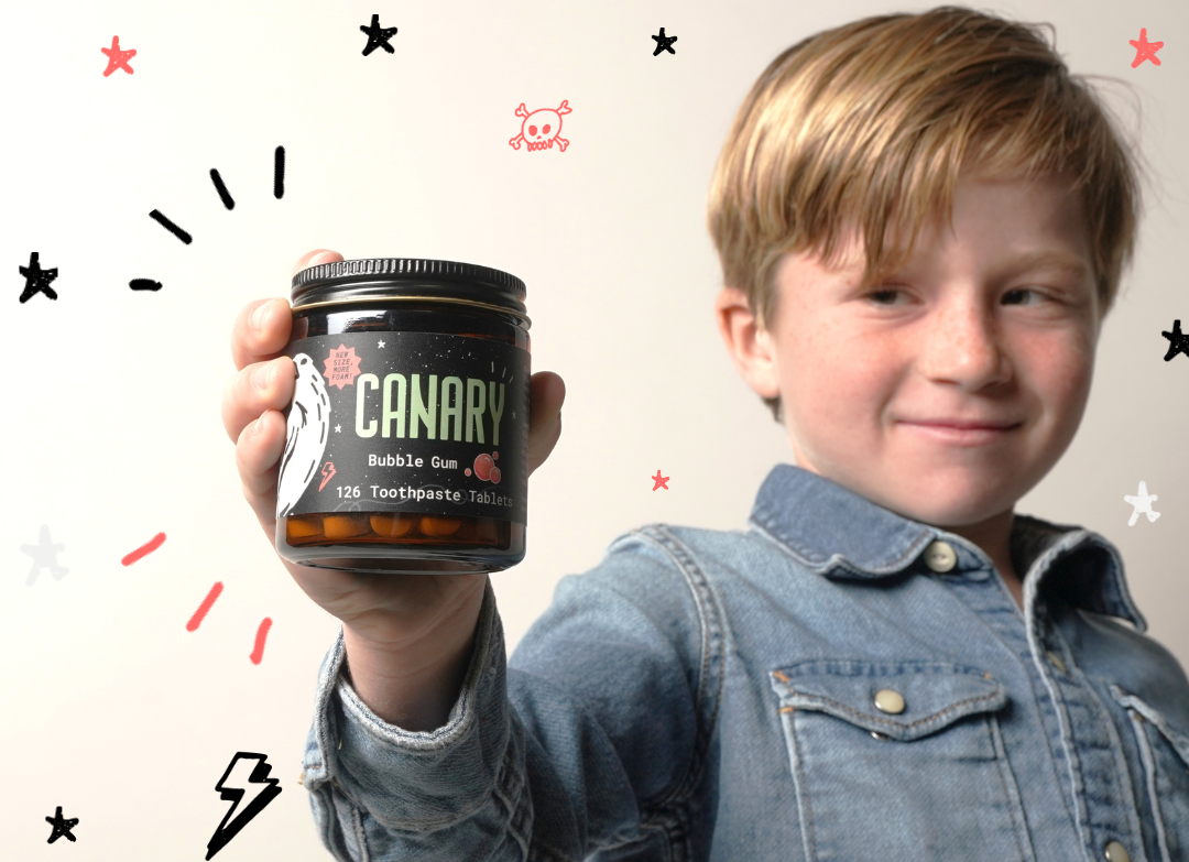 Kid holding Canary Bubblegum flavored toothpaste tablets. Kids love them for the taste and parents love them for the ingredients and less mess. 