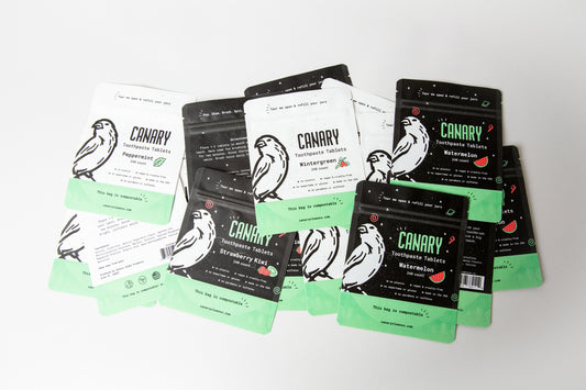 Canary Toothpaste Tablets pouches laid out. Watermelon, Peppermint, Wintergreen, and Strawberry Kiwi Flavored. 