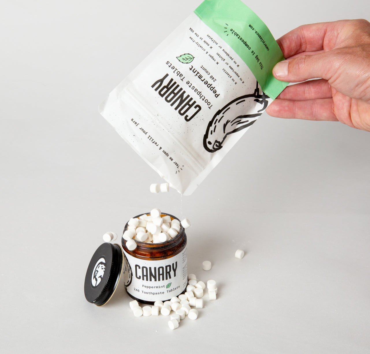 Canary Peppermint Toothpaste tablets being poured from pouch to jar. Eco-Friendly, Vegan, Fluoride Free