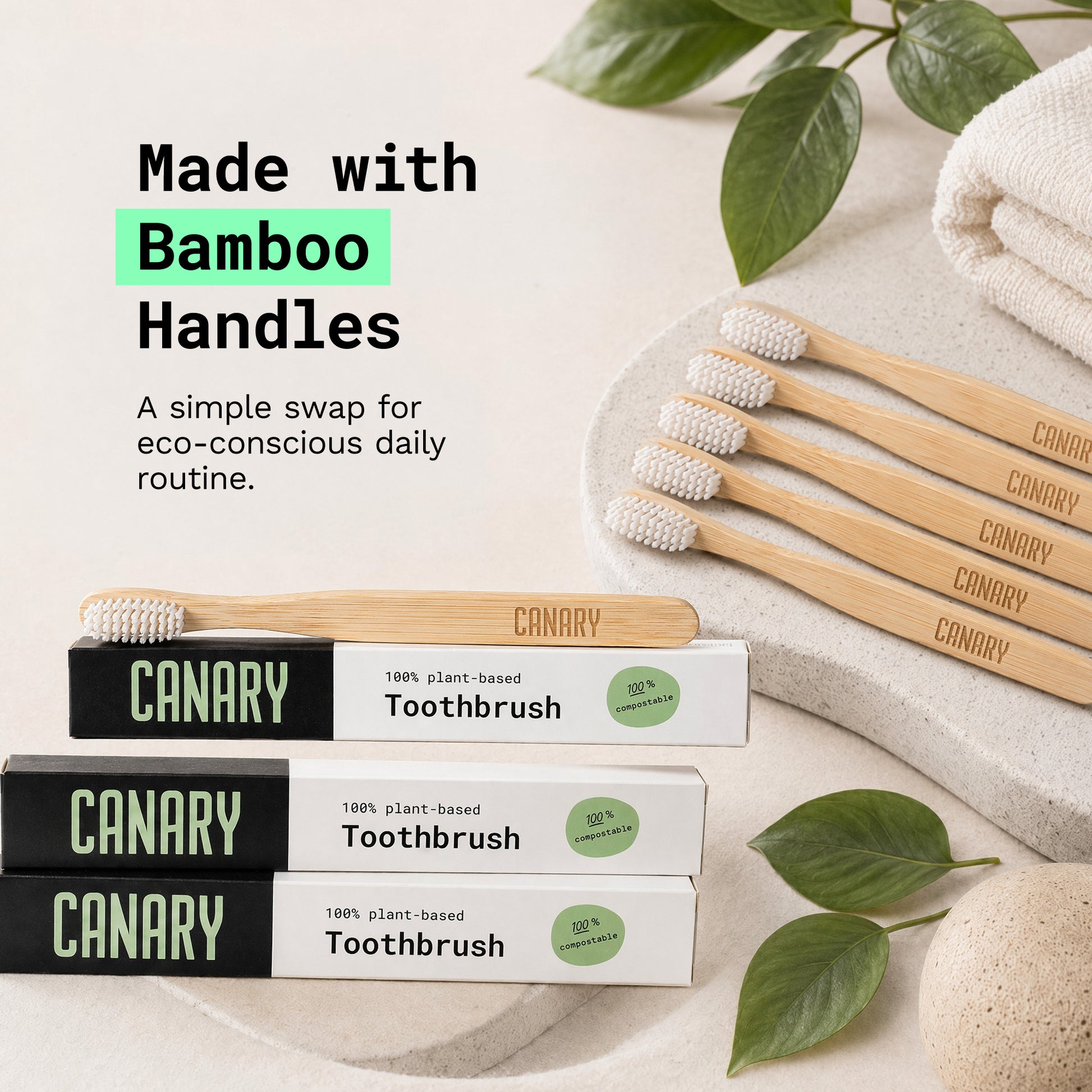 Close up image of canary plant based bamboo toothbrush on bathroom sink with packaging and plants surrounding the product.