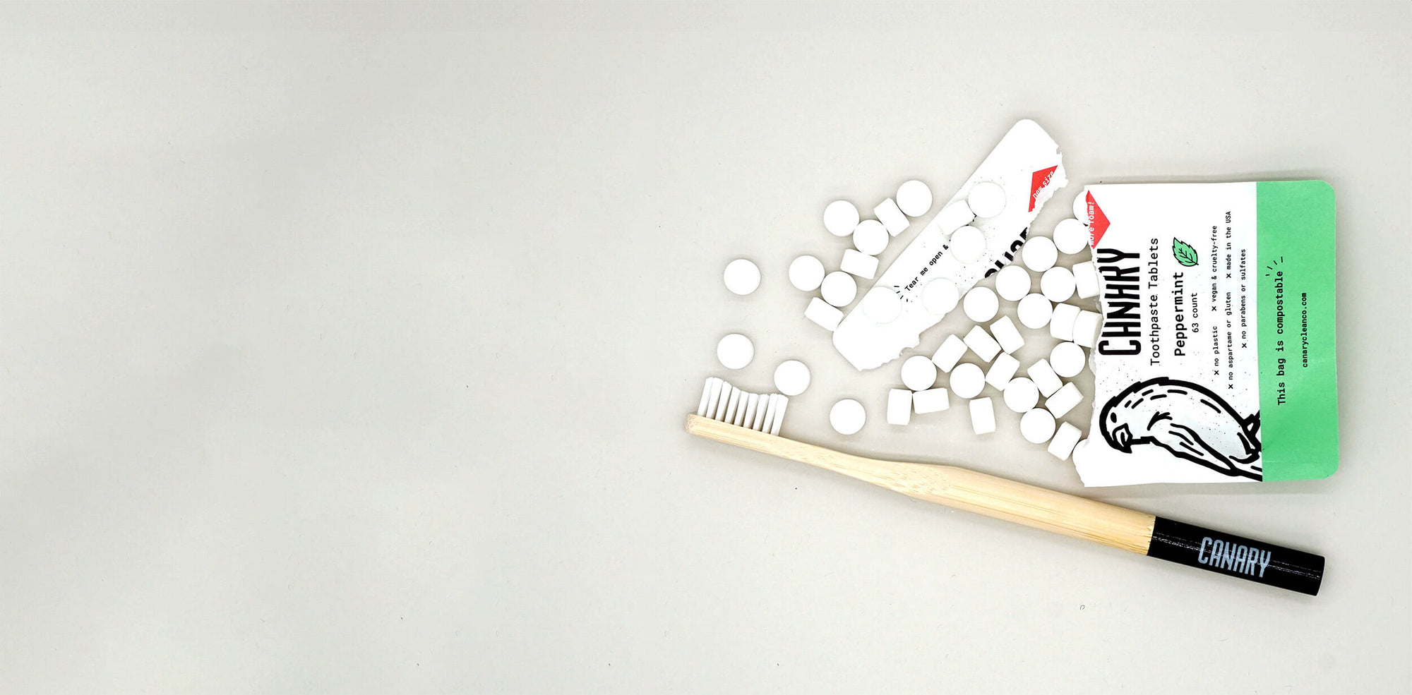 Horizontal Image of Peppermint Toothpaste Tablets.63 Count. Tablets and Bamboo Toothbrush around product.