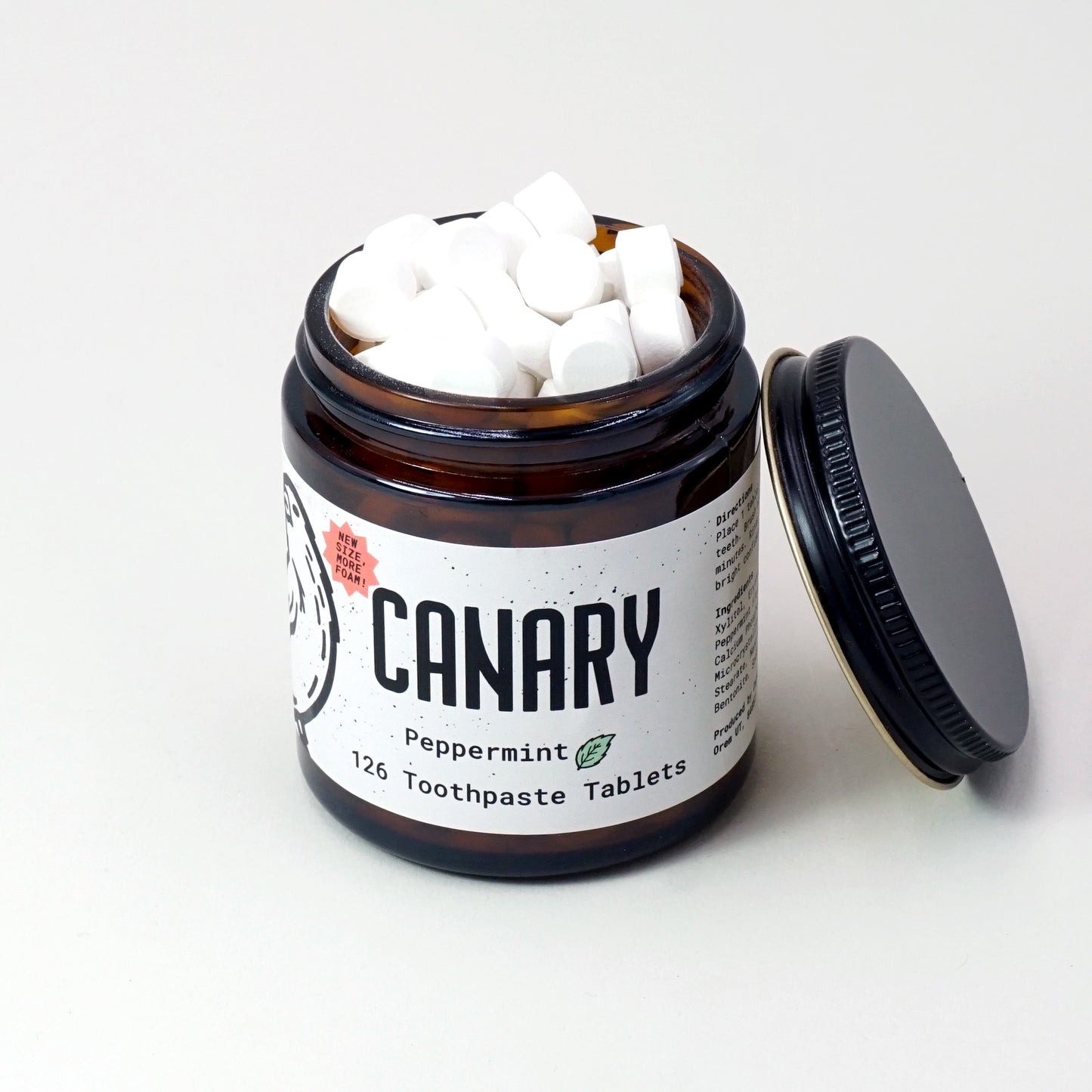 New and improved Canary Peppermint Toothpaste Tablets, 126 count jar, view from top peeking into jar at the tablets