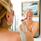 Tori applying Canary Rhassoul Clay + Rose Face Mask to her face with a facial brush while looking in the mirror
